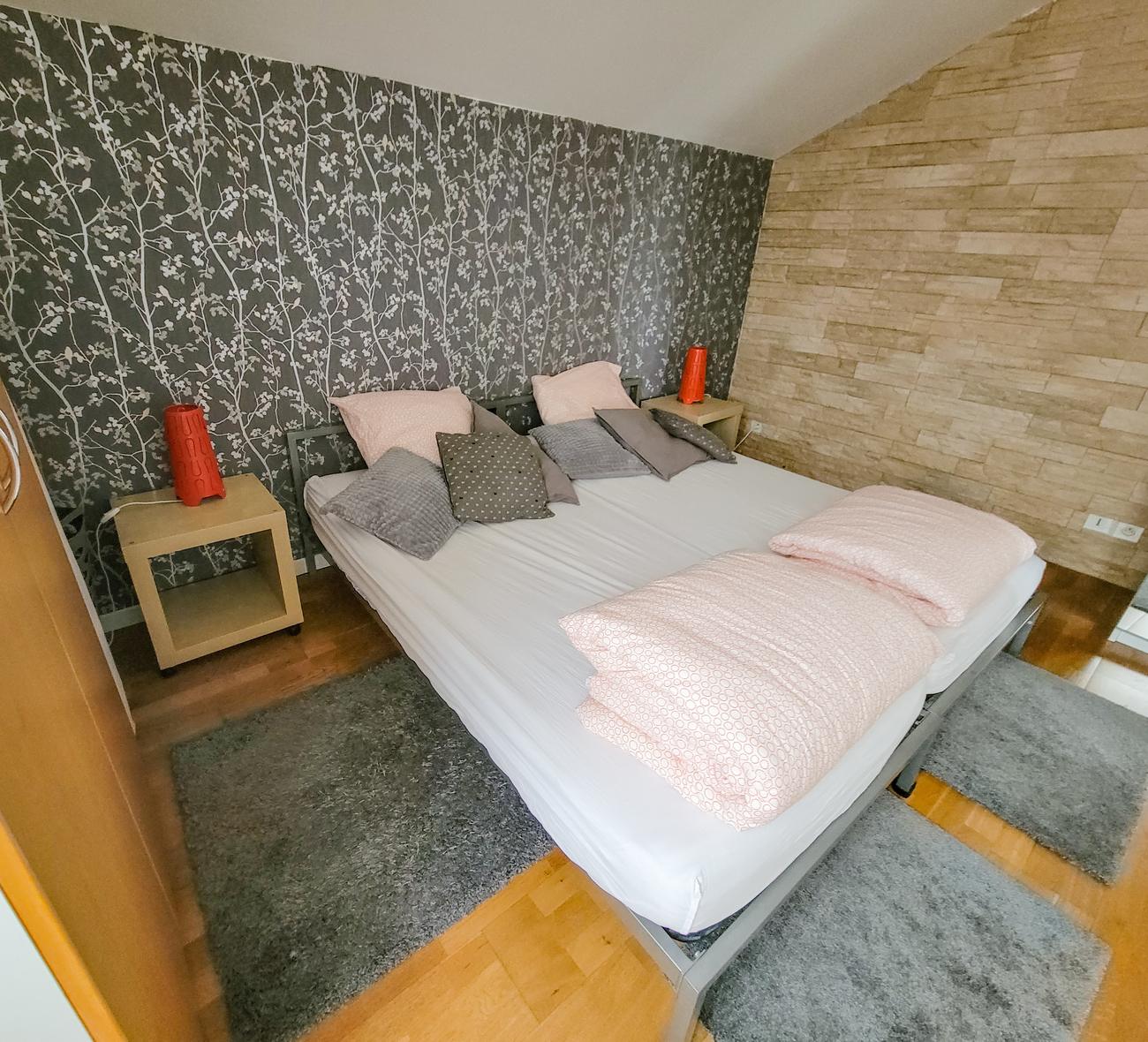 Chambre avec deux lits jumeaux assemblés et papier peint à motif de branches