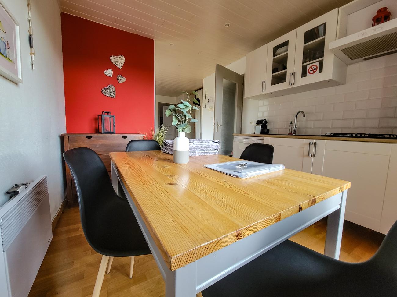 Table en bois massif et chaises noires près de la cuisine